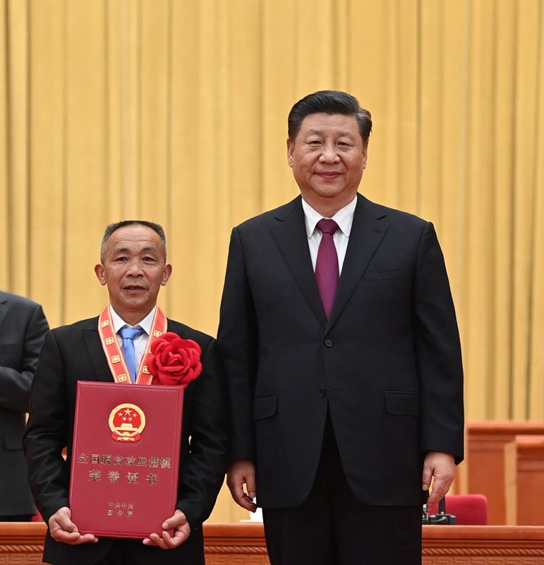 2021年2月25日，全国脱贫攻坚总结表彰大会在北京人民大会堂隆重举行。这是习近平为全国脱贫攻坚楷模荣誉称号获得者毛相林颁奖。 新华社记者 李学仁摄